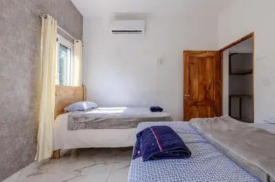 a bedroom with two beds and a window at Luxurious Home with Pool! in San Felipe de Puerto Plata