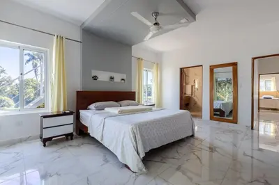 a white bedroom with a bed and a window at Luxurious Home with Pool! in San Felipe de Puerto Plata