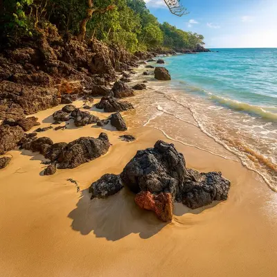 a beach with rocks on the sand and the ocean at Ocean Front Escape in Las Terrenas