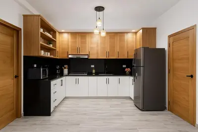 a kitchen with white cabinets and a black refrigerator at Ocean Front Escape in Las Terrenas