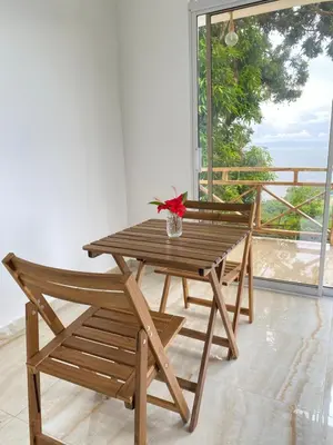 a wooden table and chairs with a view of the ocean at Apartamento con Vista al Mar PalmeritaVillage in El Valle