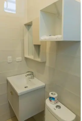 a white bathroom with a toilet and a sink at Esmeralda modern apartment at Romana del Oeste in La Romana