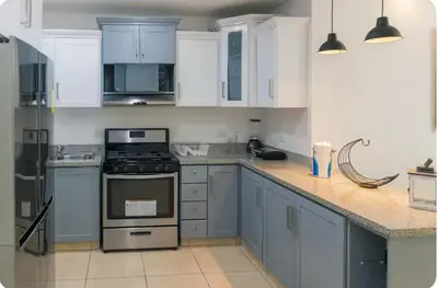 a kitchen with white cabinets and a stove top oven at Esmeralda modern apartment at Romana del Oeste in La Romana