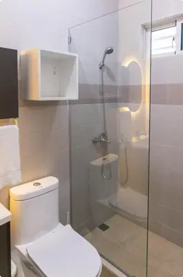 a bathroom with a toilet and a glass shower at Esmeralda modern apartment at Romana del Oeste in La Romana
