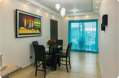 a dining room with a black table and chairs at Esmeralda modern apartment at Romana del Oeste in La Romana
