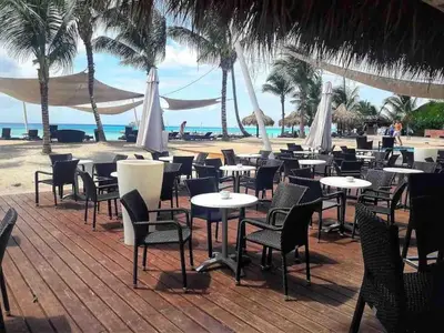 a bunch of tables and chairs on the beach at Lovely apartment by the Caribbean in Bayahibe