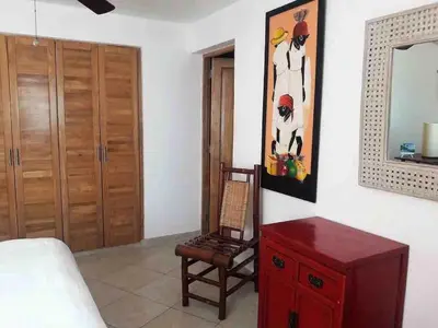 a living room with a chair and a mirror at Lovely apartment by the Caribbean in Bayahibe