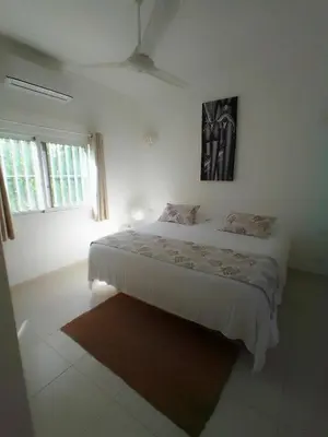 a white bedroom with a bed and a picture on the wall at Beach Hotel Casa Nina in Las Terrenas