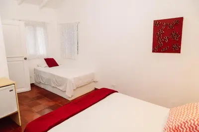 a white room with two beds and a table at Beach Hotel Casa Nina in Las Terrenas