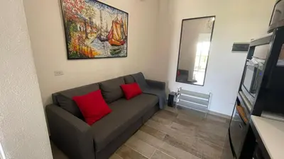 a living room with a couch with two red pillows at Residencial Paraiso in Bayahibe