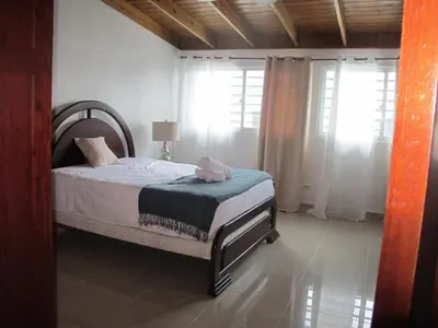 a bedroom with a bed in a room with windows at Oasis Colonial in Santo Domingo