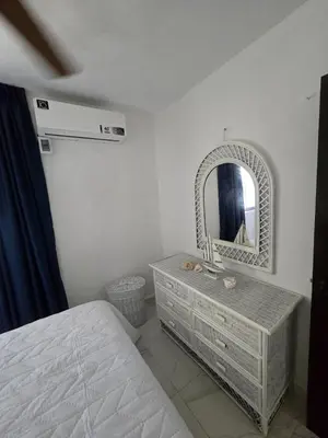 a bedroom with a bed and a dresser with a mirror at Apartamento Playa Juan dolio in Villas del Mar