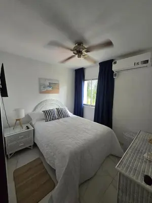 a bedroom with a bed and a ceiling fan at Apartamento Playa Juan dolio in Villas del Mar