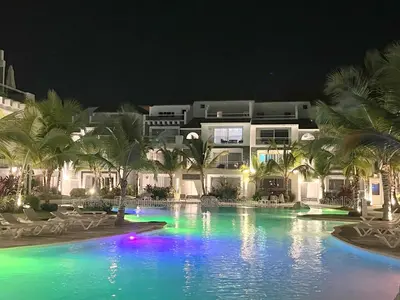 a swimming pool in front of a hotel at night at Estrella Dominicus Apartamento - Bayahibe in Bayahibe