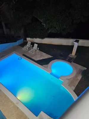 a swimming pool at night with two chairs around it at Full Department 2 hab in Las Terrenas