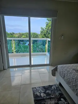 a bedroom with a bed and a view of a balcony at Full Department 2 in Las Terrenas