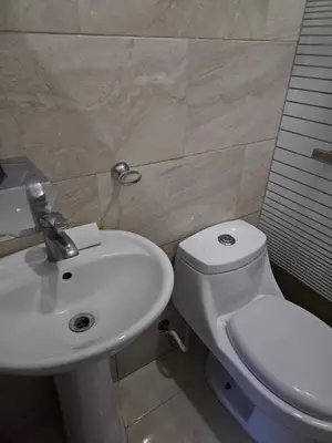 a bathroom with a white toilet and a sink at Full Department 2 in Las Terrenas