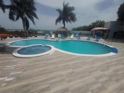 a large swimming pool with chairs and a table at villa cueva del padre pio in Santiago de los Caballeros