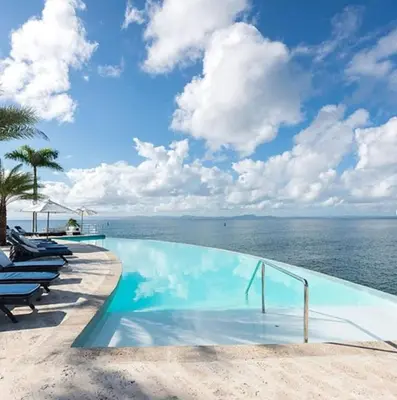 a swimming pool with a view of the ocean at Penthouse Suite at Puerto Bahia in Samana in Los Grini