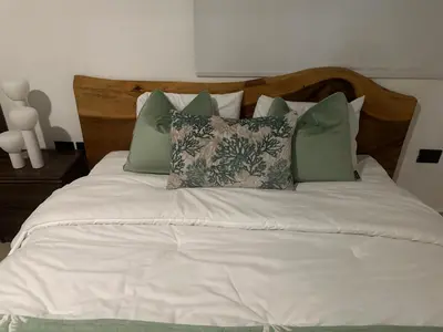 a bed with green and white pillows on it at Villa Paz in La Romana