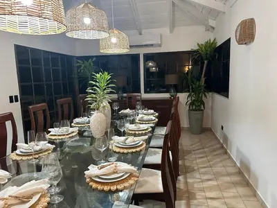 a dining room with a long glass table with chairs at Villa Paz in La Romana