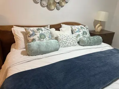a bed with blue and white pillows on it at Villa Paz in La Romana
