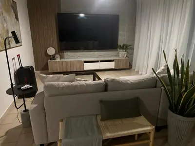 a living room with a couch and a flat screen tv at Villa Paz in La Romana