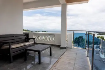 a balcony with a bench and a view of the ocean at Villas Hillside apt 3 in Santa Bárbara de Samaná