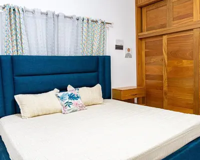 a bed with a blue headboard in a room at Modern and luxurious house in Santiago in Santiago de los Caballeros
