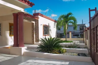 a courtyard with palm trees and a building at Casa de alquiler FIGARO in Villa Clara