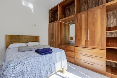 a bedroom with a bed and wooden cabinets at Luxurious Home with Pool in San Felipe de Puerto Plata