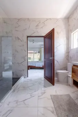 a bathroom with a toilet and a glass door at Luxurious Home with Pool in San Felipe de Puerto Plata