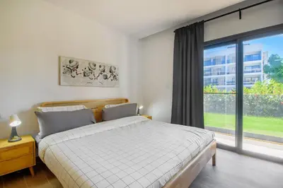 a bedroom with a bed and a large window at Bran new condo with pool access in Punta Cana