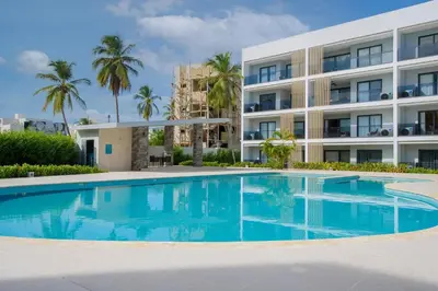 a swimming pool in front of a building at Bran new condo with pool access in Punta Cana