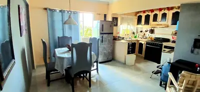 a kitchen with a table and chairs and a refrigerator at Sol Mar Alegre II in Boca Chica