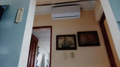 a hallway with a ceiling fan and pictures of boats on the wall at Sol Mar Alegre II in Boca Chica