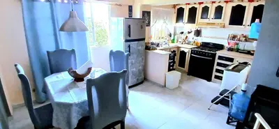 a kitchen with a table and chairs and a refrigerator at Sol Mar Alegre II in Boca Chica
