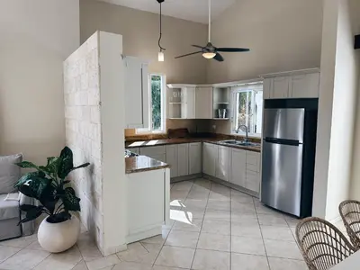 a kitchen with white cabinets and a stainless steel refrigerator at Casa Caipirinha Encuentro in Cabarete