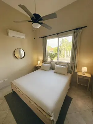 a bedroom with a large bed with a ceiling fan at Casa Caipirinha Encuentro in Cabarete