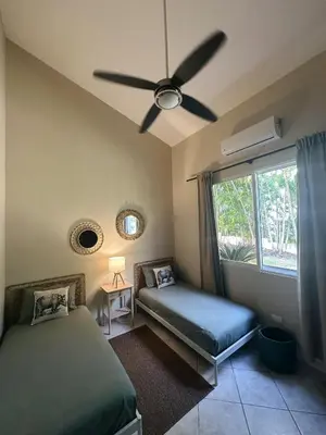 a bedroom with two beds and a ceiling fan at Casa Caipirinha Encuentro in Cabarete