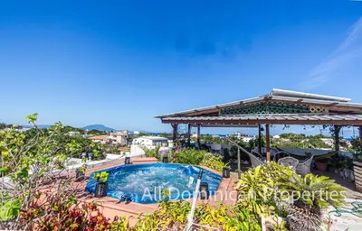 a swimming pool with a pergola and a house at Unusual Artist's Loft with jacuzzi and Roof Terrace in Sosúa