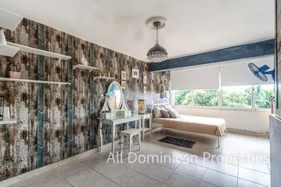 a living room with a couch and a mirror at Unusual Artist's Loft with jacuzzi and Roof Terrace in Sosúa