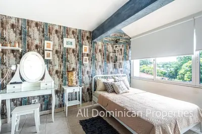 a bedroom with a bed and a desk and a window at Unusual Artist's Loft with jacuzzi and Roof Terrace in Sosúa