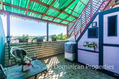 a porch with a bench and awning and a window at Unusual Artist's Loft with jacuzzi and Roof Terrace in Sosúa