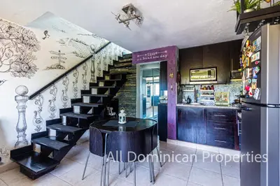 a dining room with a table and a staircase at Unusual Artist's Loft with jacuzzi and Roof Terrace in Sosúa