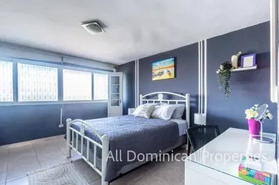 a blue bedroom with a bed and a table at Unusual Artist's Loft with jacuzzi and Roof Terrace in Sosúa