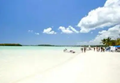a group of people standing on a white beach at Vista al mar in Boca Chica