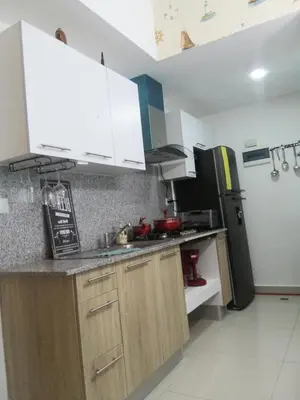 a kitchen with white cabinets and a black refrigerator at Vista al mar in Boca Chica