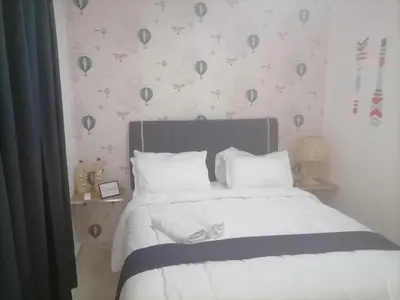 a bedroom with a bed with white sheets and birds on the wall at Vista al mar in Boca Chica
