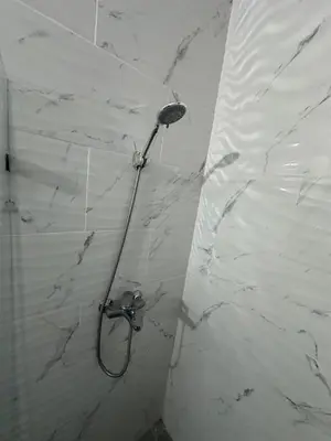 a shower in a bathroom with a white marble wall at Apartahotel-E vista catalina in La Romana